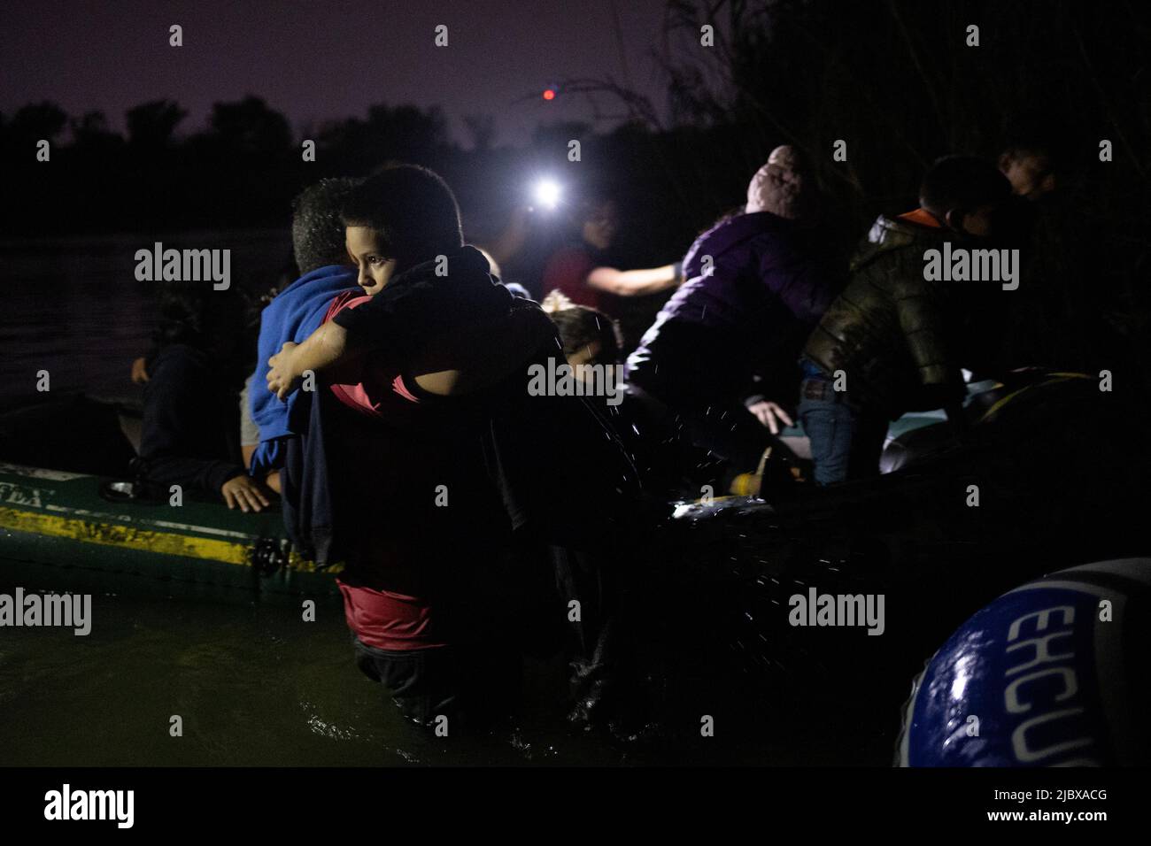 Emerson, a seven year old unaccompanied boy from Guatemala, is assisted by another asylum seeking migrant after the group crossed the Rio Grande river into the United States from Mexico in Roma, Texas, June 8, 2022.  REUTERS/Adrees Latif Stock Photo