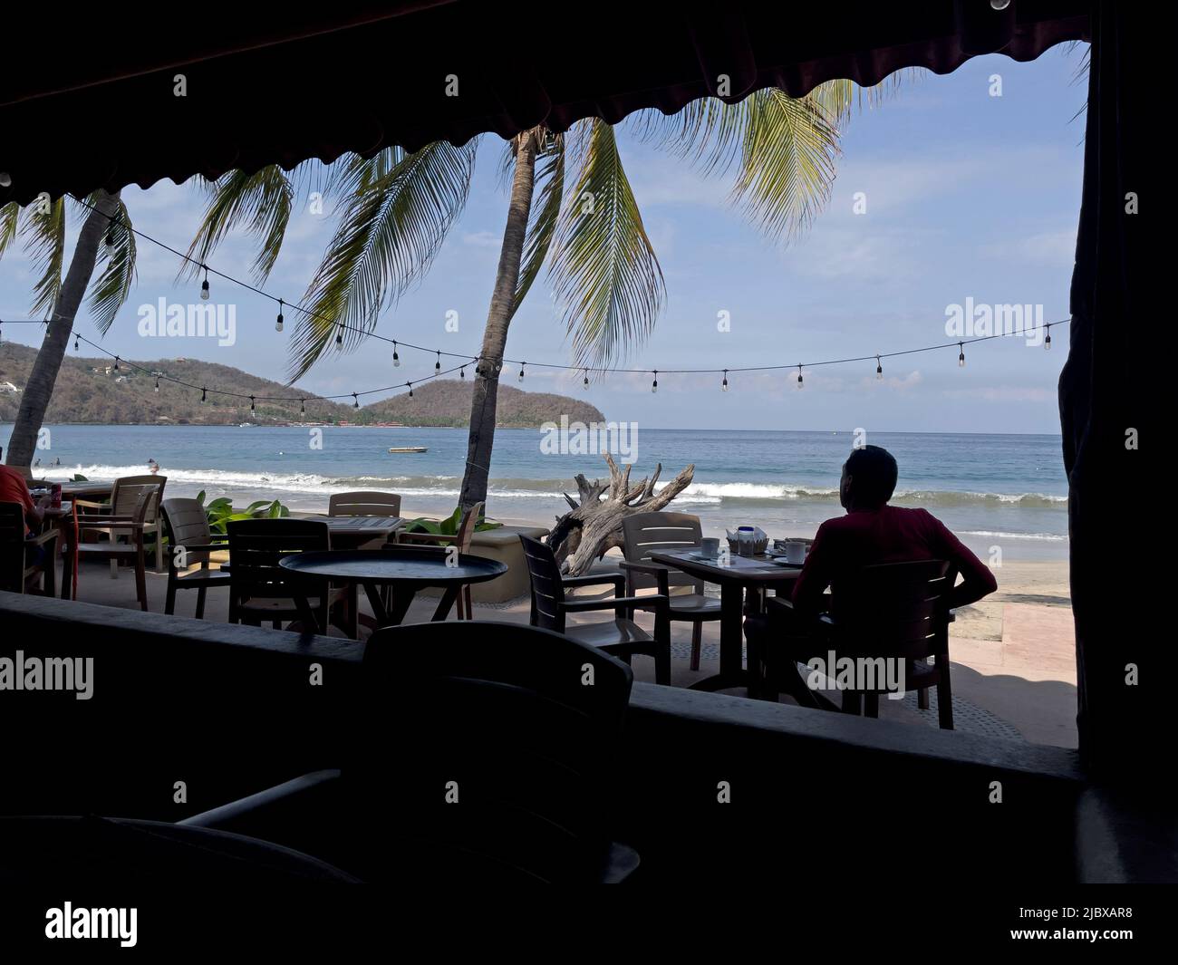 Dining at outdoor restaurant at the beach at La Playa Ropa in Zihuatanejo, Mexico Stock Photo
