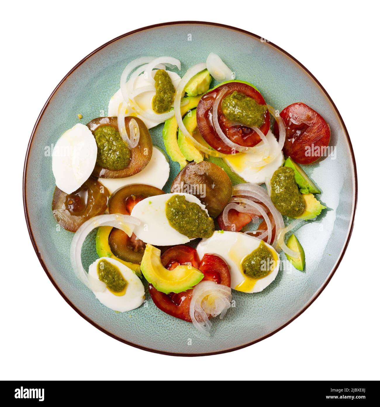 Caprese avocado salad with tomatoes, mozzarella, onion and pesto Stock Photo