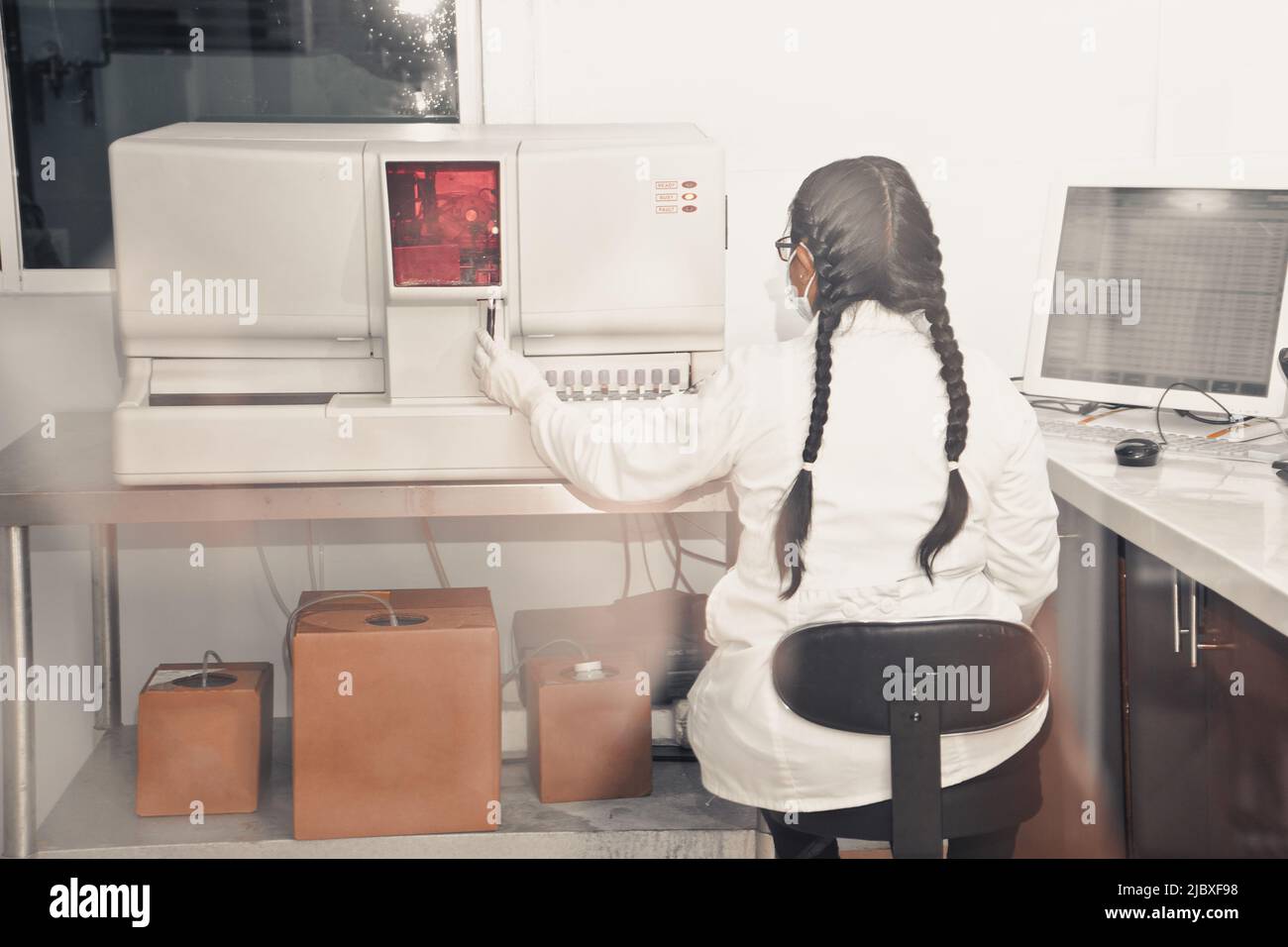 Unrecognizable clinical analyst from the back putting blood samples