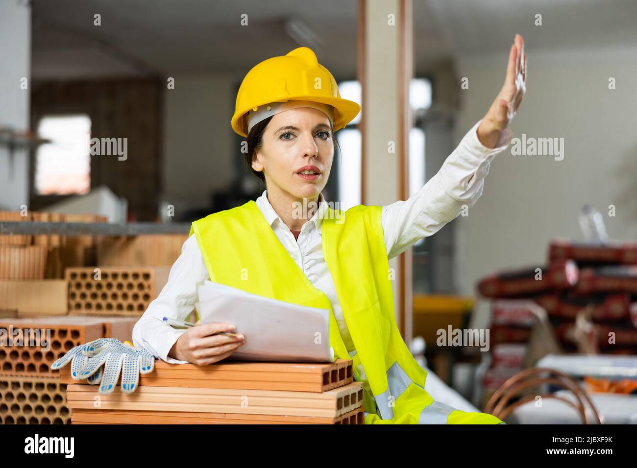 Strict female supervisor making stop gesture while inspecting construction site Stock Photo