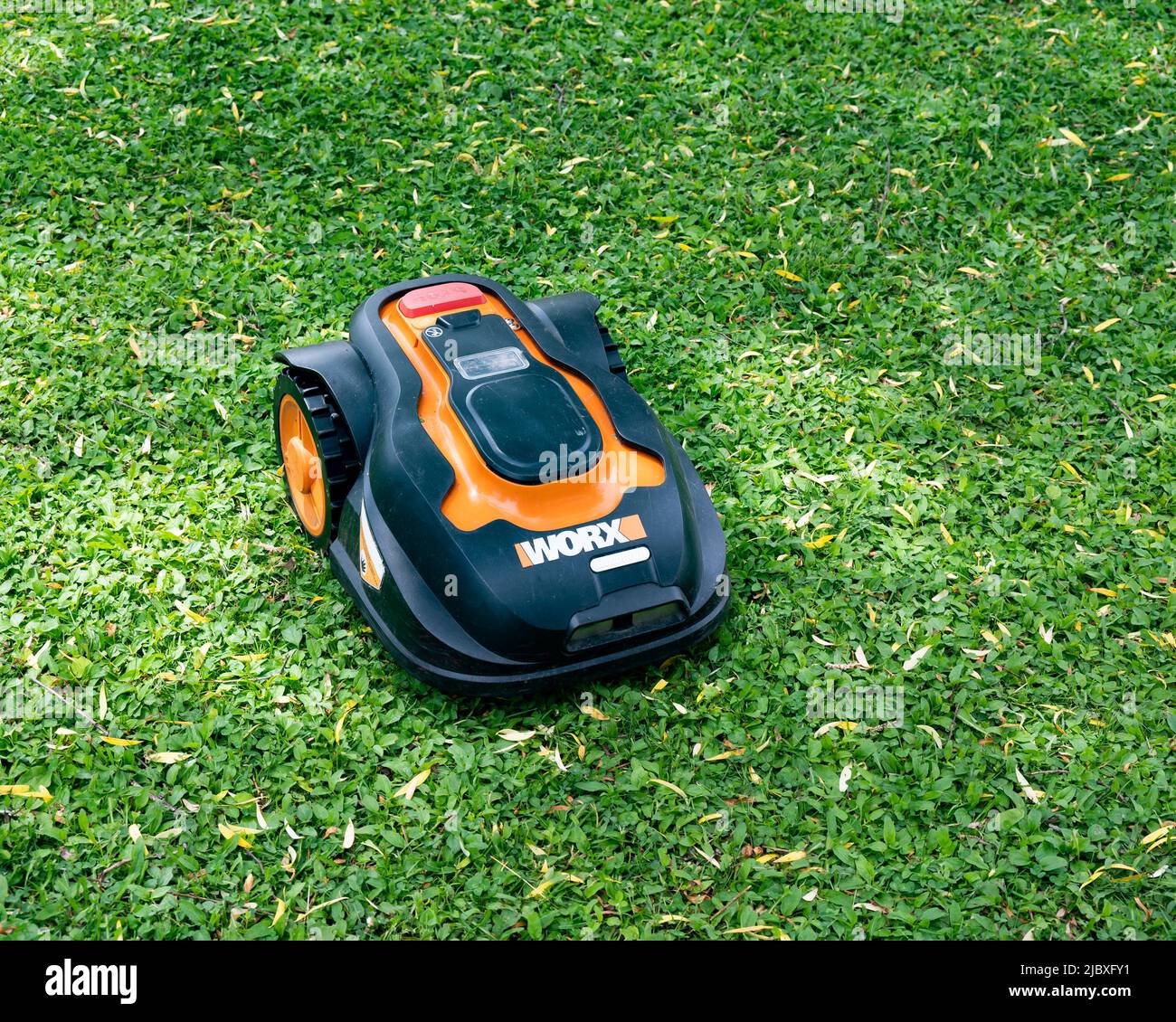 A Worx robotic lawn mower mowing a lawn Stock Photo