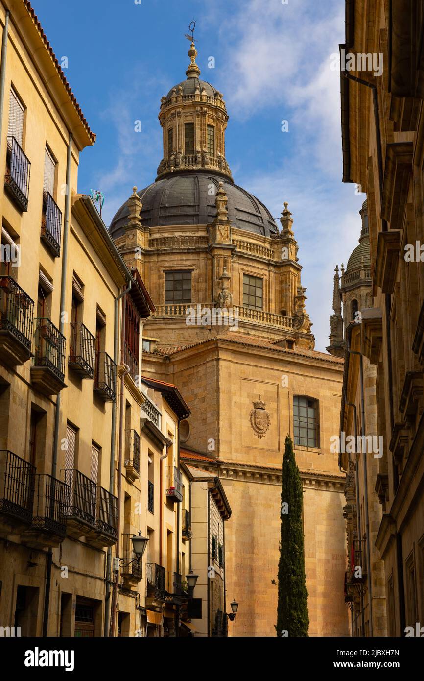Baroque dome of La Clerecia dominating narrow street of Salamanca Stock Photo