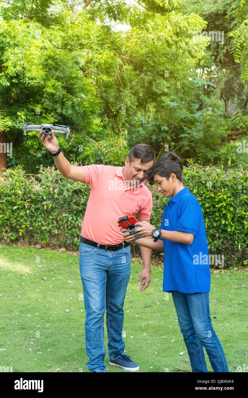 Father and son playing with drone in the garden Stock Photo - Alamy