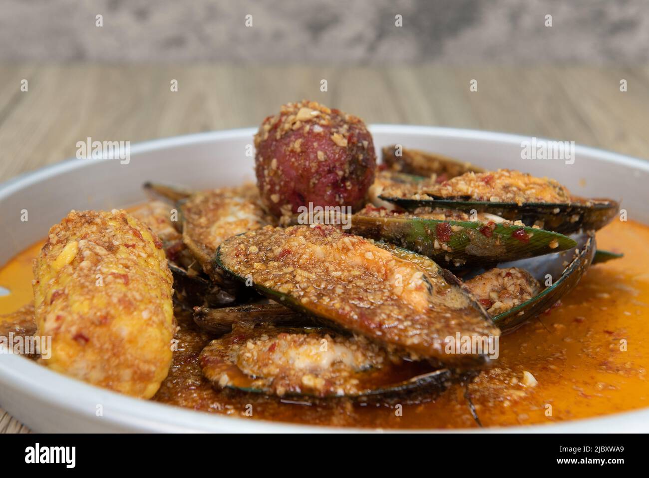 Delicious buttery and seasoned plate of green mussels in the shell with