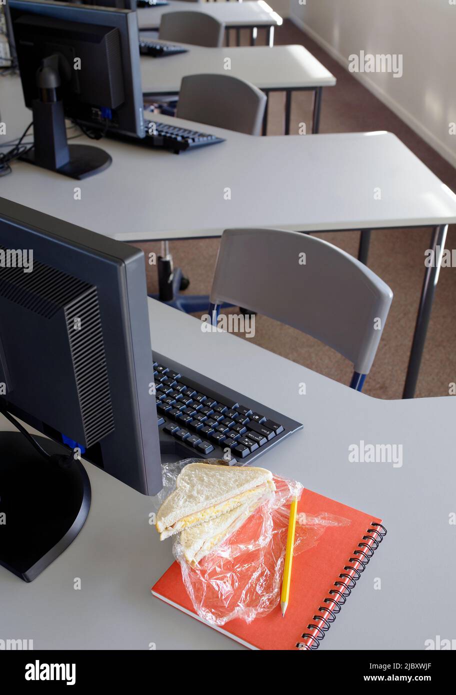 Sandwich resting on desk next to computer in school computer room Stock ...