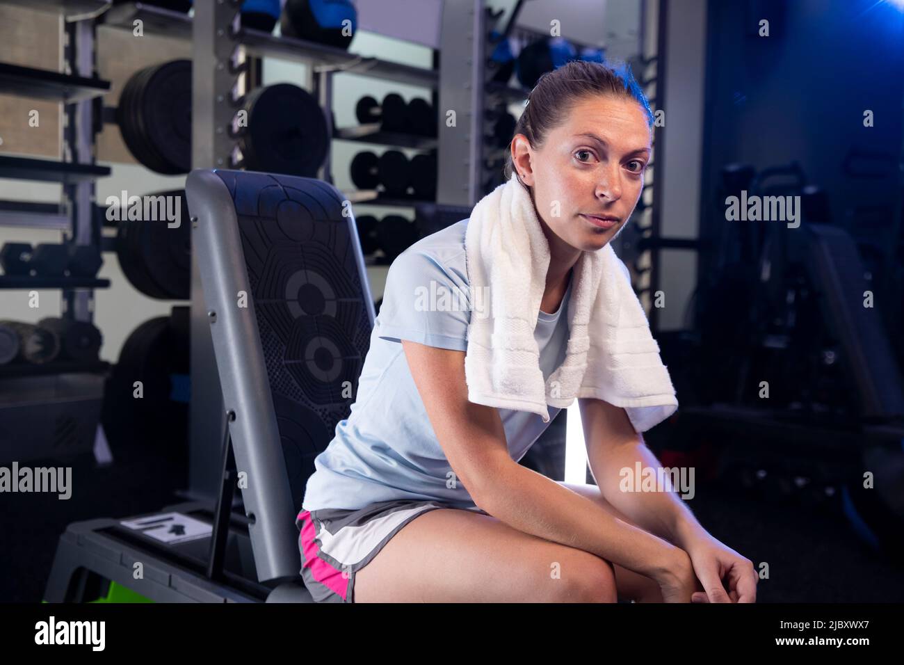 Young woman with towel around her neck looking into camera while ...