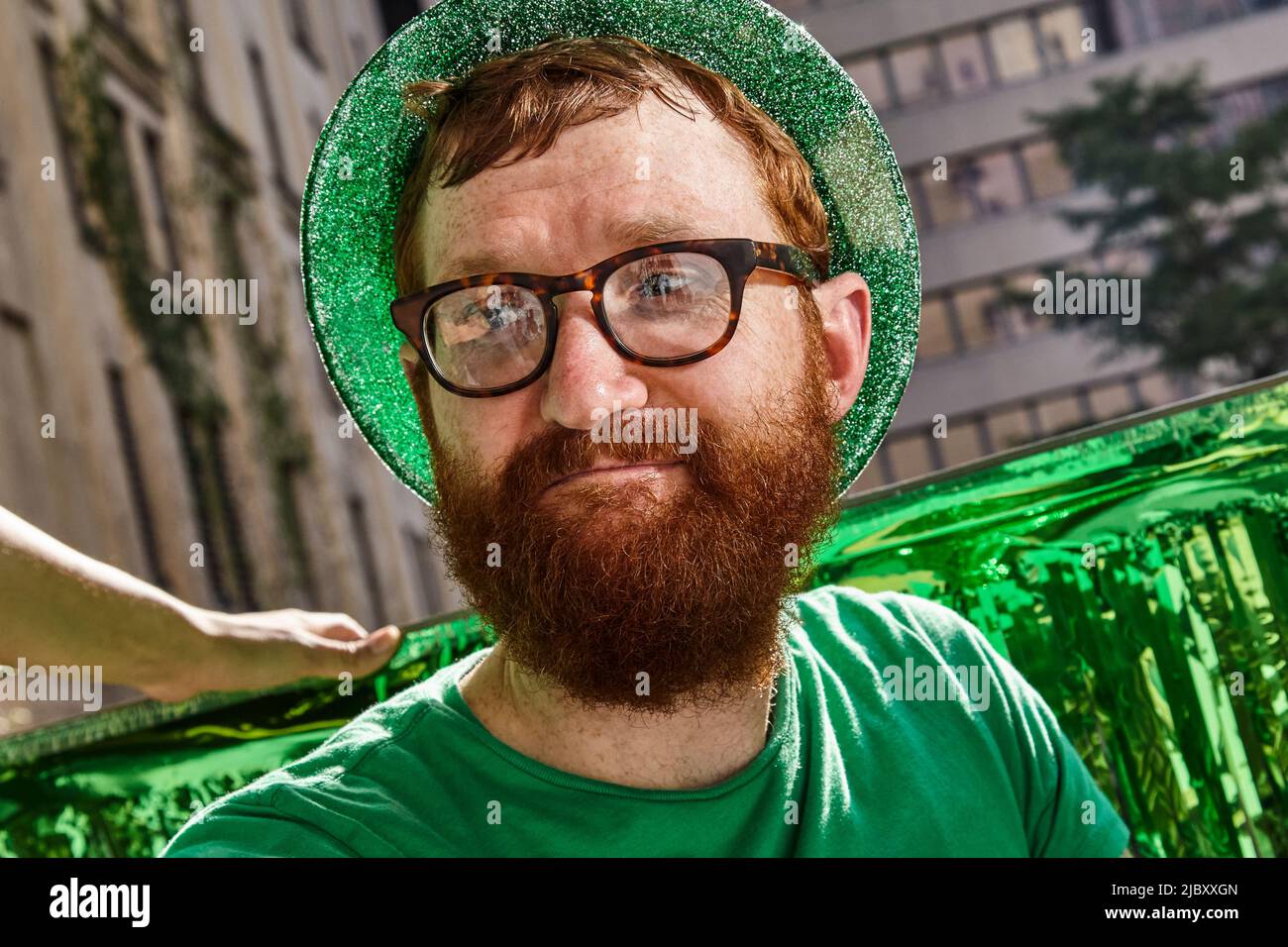 Redheaded man wearing green hat and shirt at St Patrick's Day Party Stock Photo