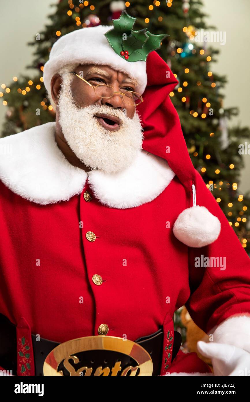 Santa Claus laughing and looking off camera against Christmas background Stock Photo