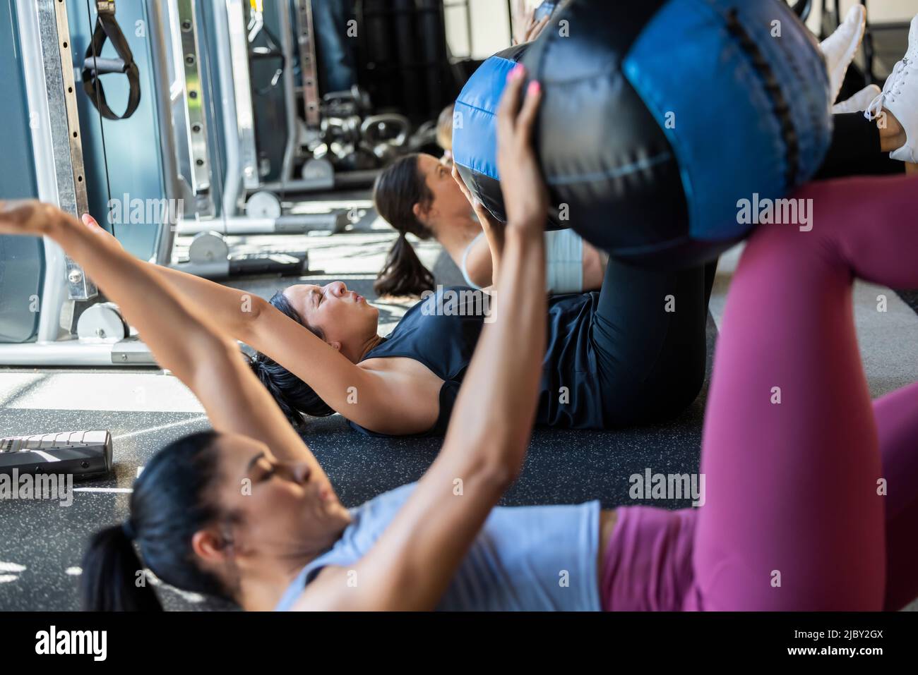 Determined woman in fitness class in gym making a painful face during