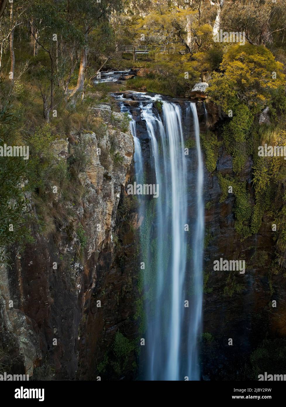 Looking from the top of Queen Mary Falls at the water flowing down rocky cliff face Stock Photo