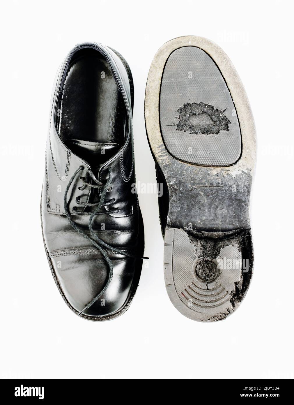 Pair of worn black leather shoes with holes in the sole Stock Photo Alamy