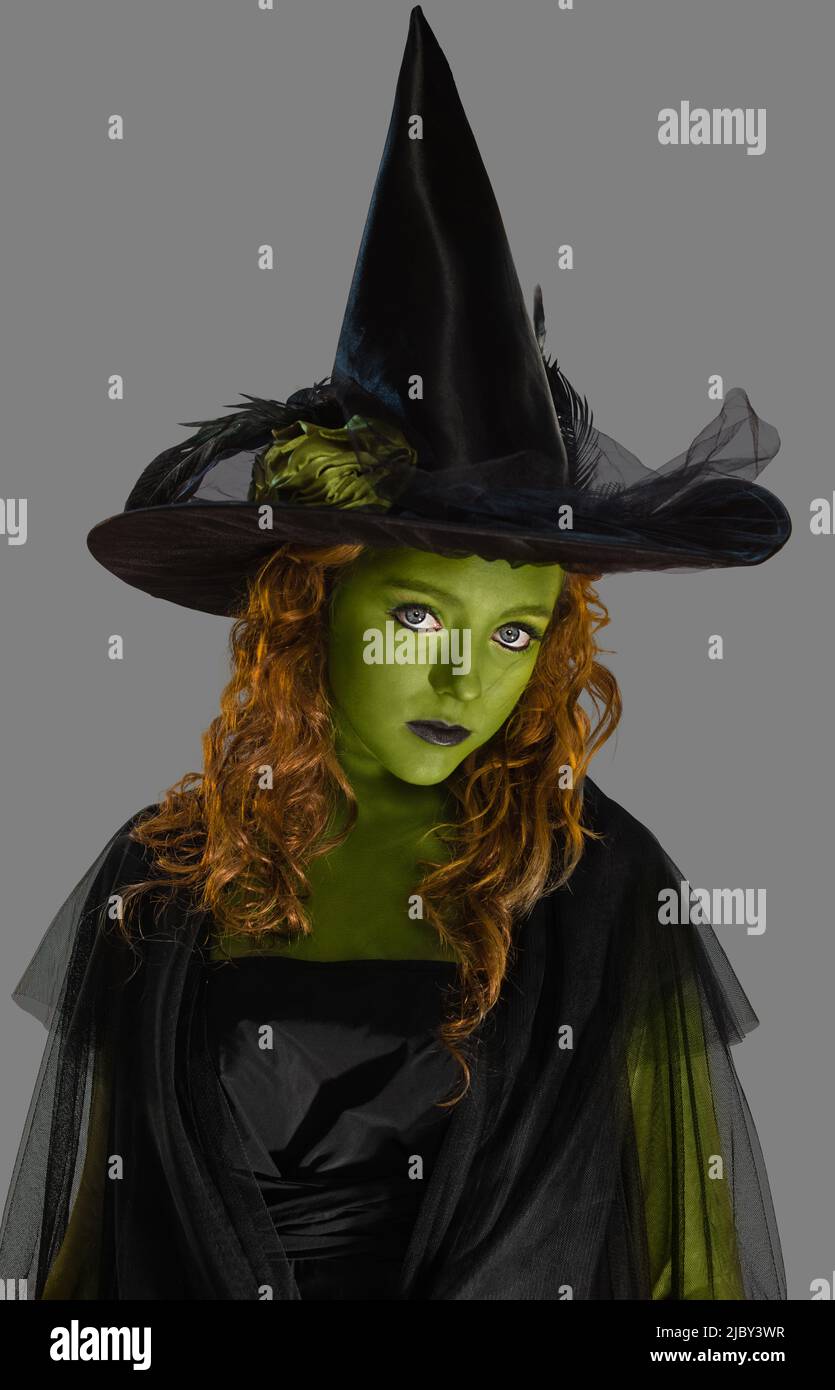 Portrait of a woman dressed as a witch with green body paint, looking ...