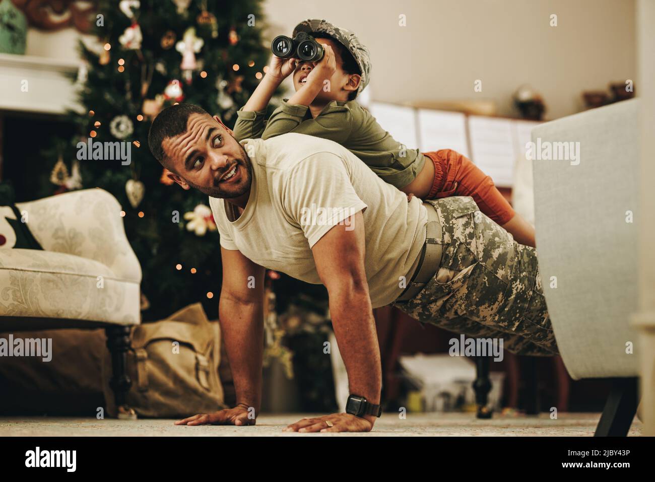 Happy military dad spending some quality time with his son at Christmas. Army soldier spending the holidays with his child after deployment. Father an Stock Photo