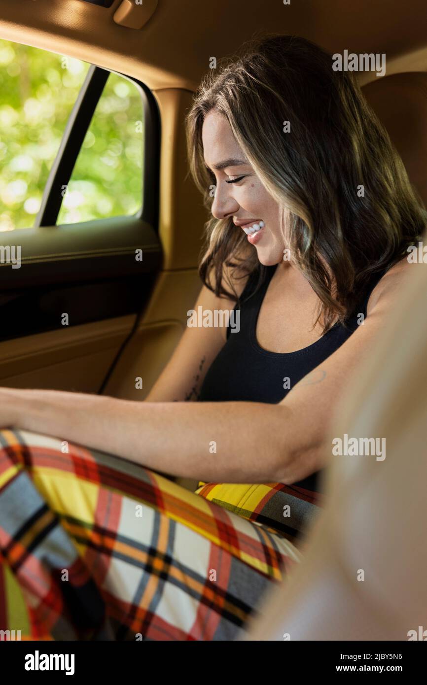 Portrait of caucasian woman laughing in backseat of luxury sedan Stock Photo