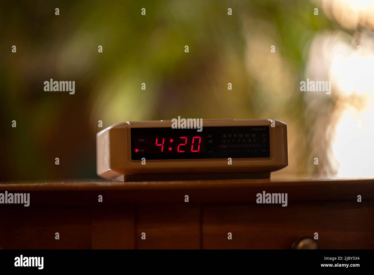 Detail of vintage digital alarm clock sitting on side table Stock Photo