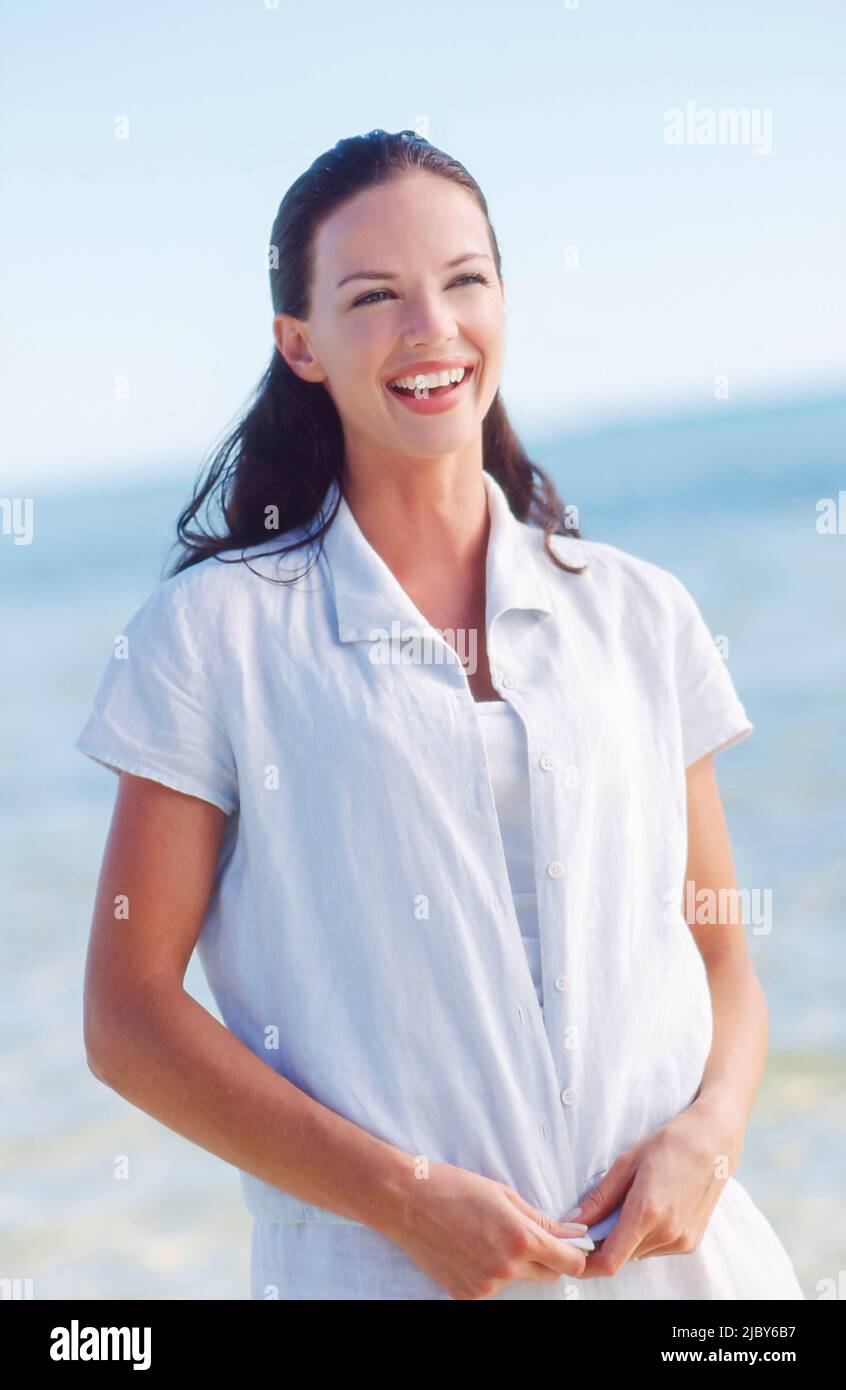 Young woman dressed in white at the beach smiling Stock Photo - Alamy