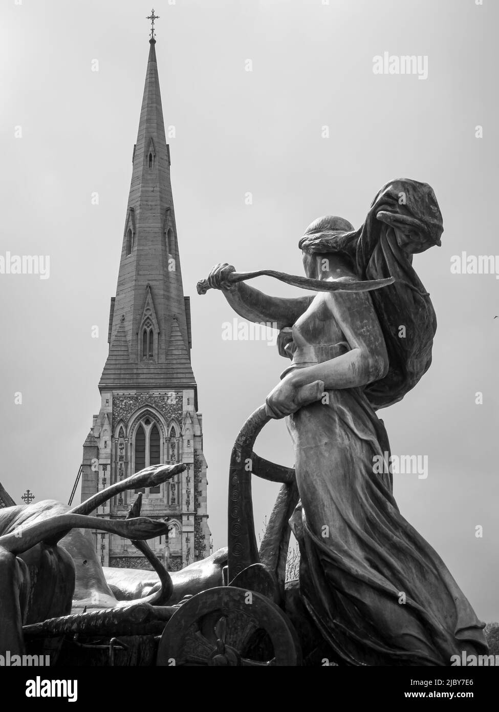 Statue in fountain across from steeple Stock Photo