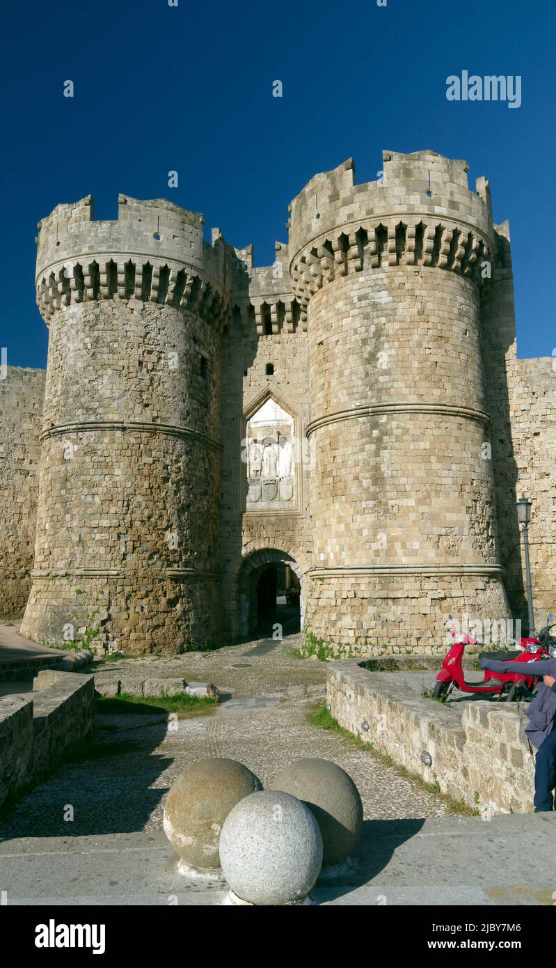 Castellated gateway, entrance to Rhodes Old Town, Rhodes Island, Greece, Dodecanese. Red scooter parked outside. Spring 2022. May. cym Stock Photo