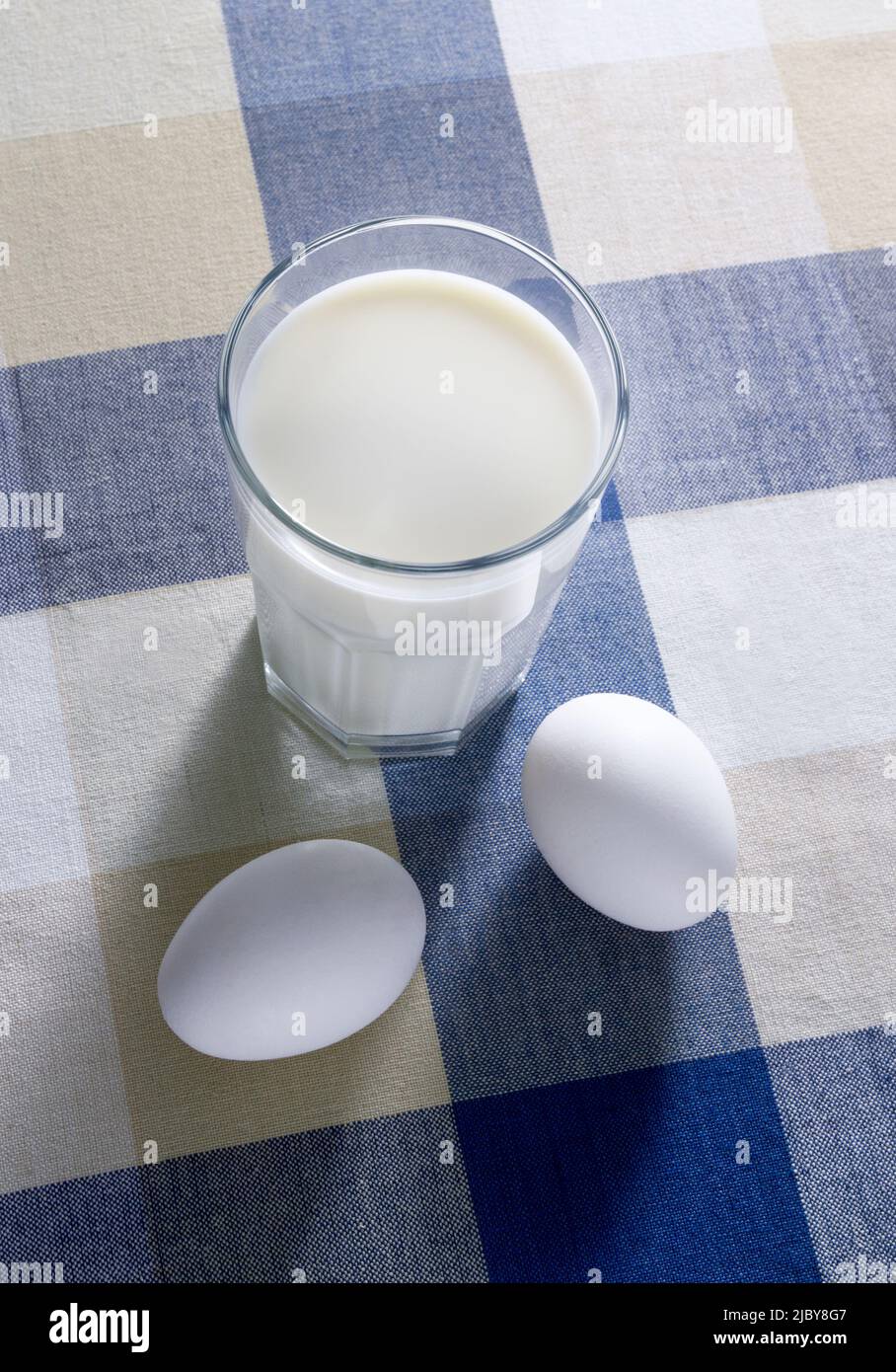 Glass of milk and eggs resting on table cloth Stock Photo - Alamy