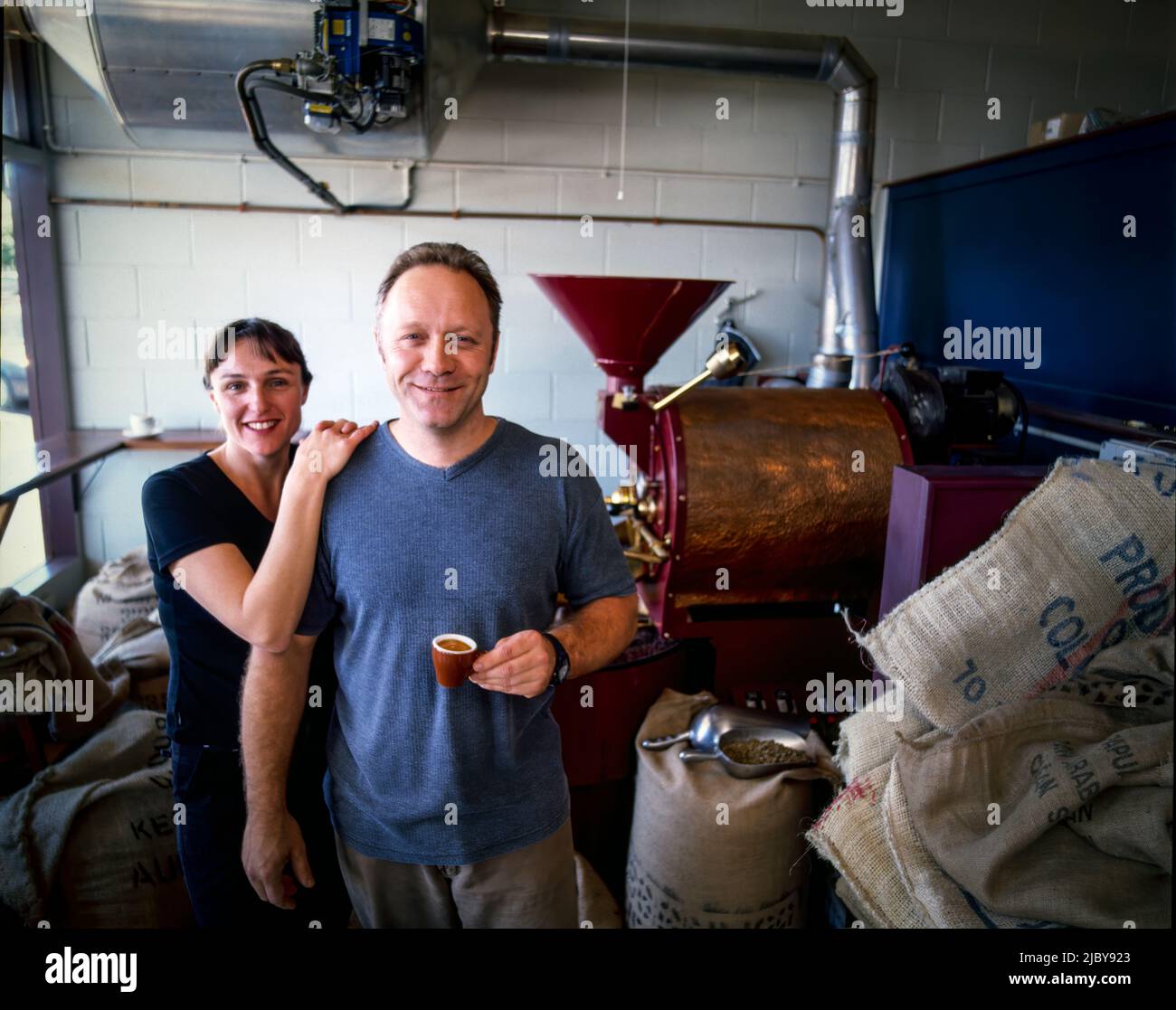 Portrait of coffee master roasters sampling cup of coffee in roasting room Stock Photo
