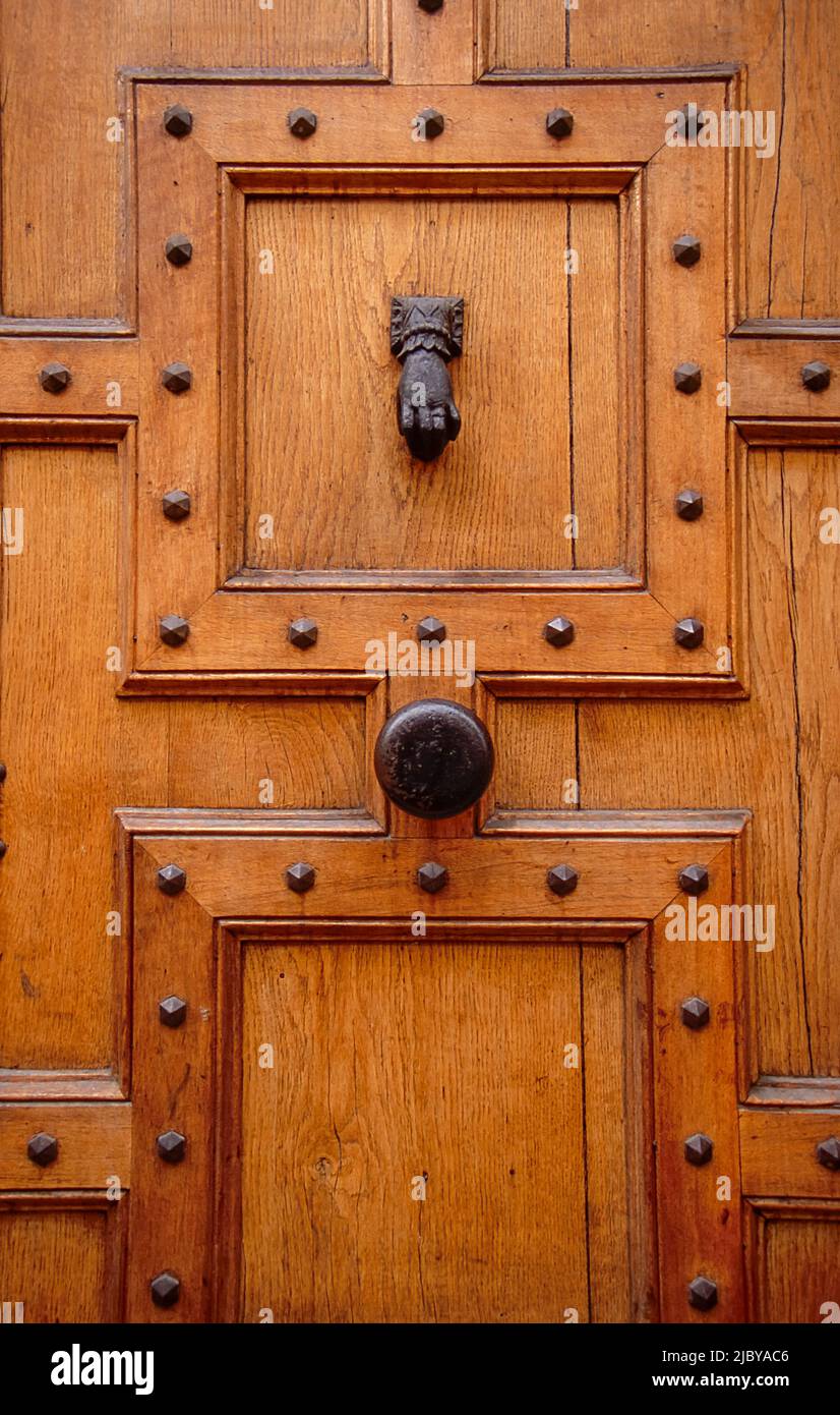 Large panneled and studded door with iron knob and knocker Stock Photo