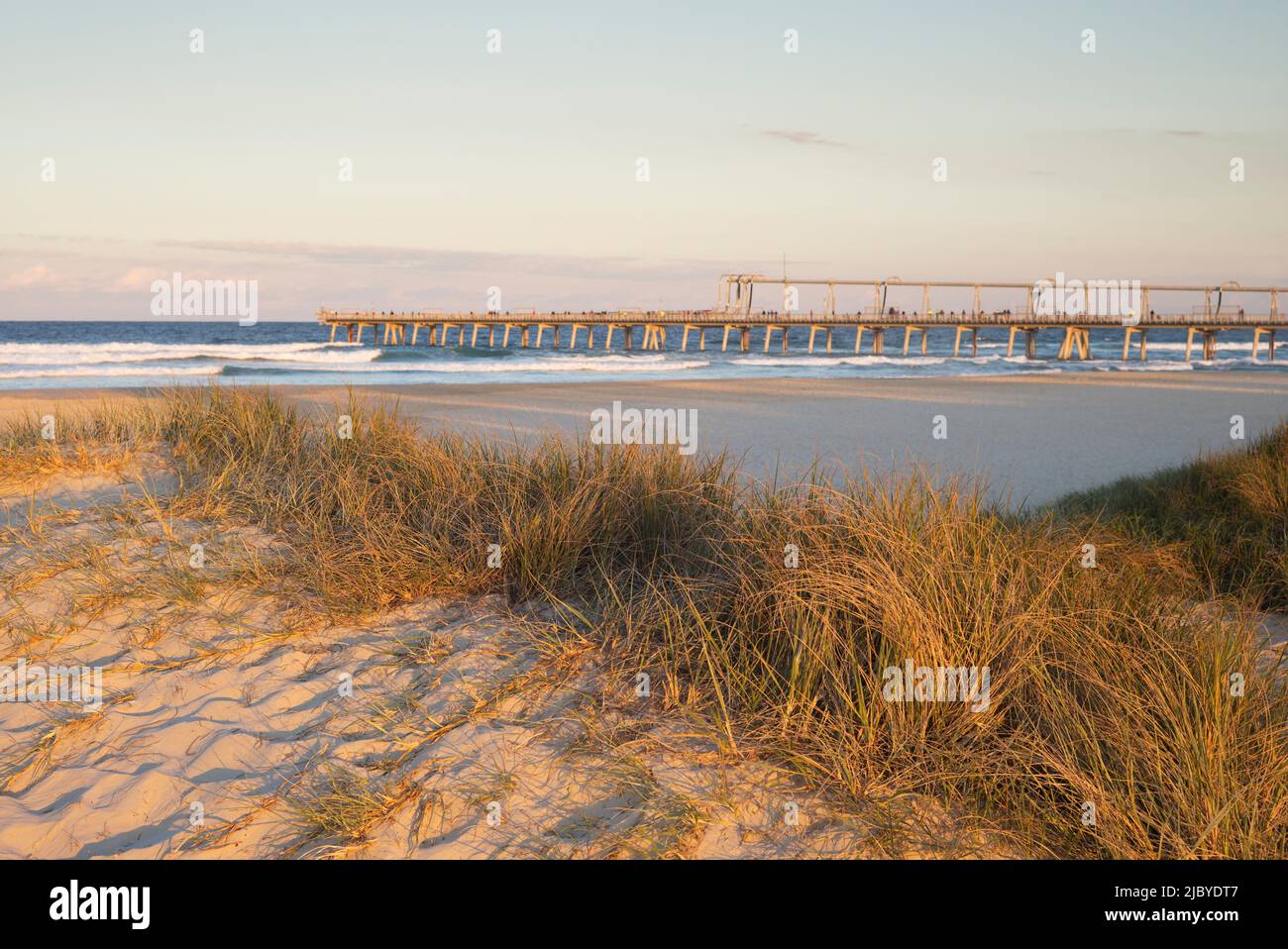 Looking over grassy sandbank at beach to the permanent sand dredge on the Gold Coast Stock Photo