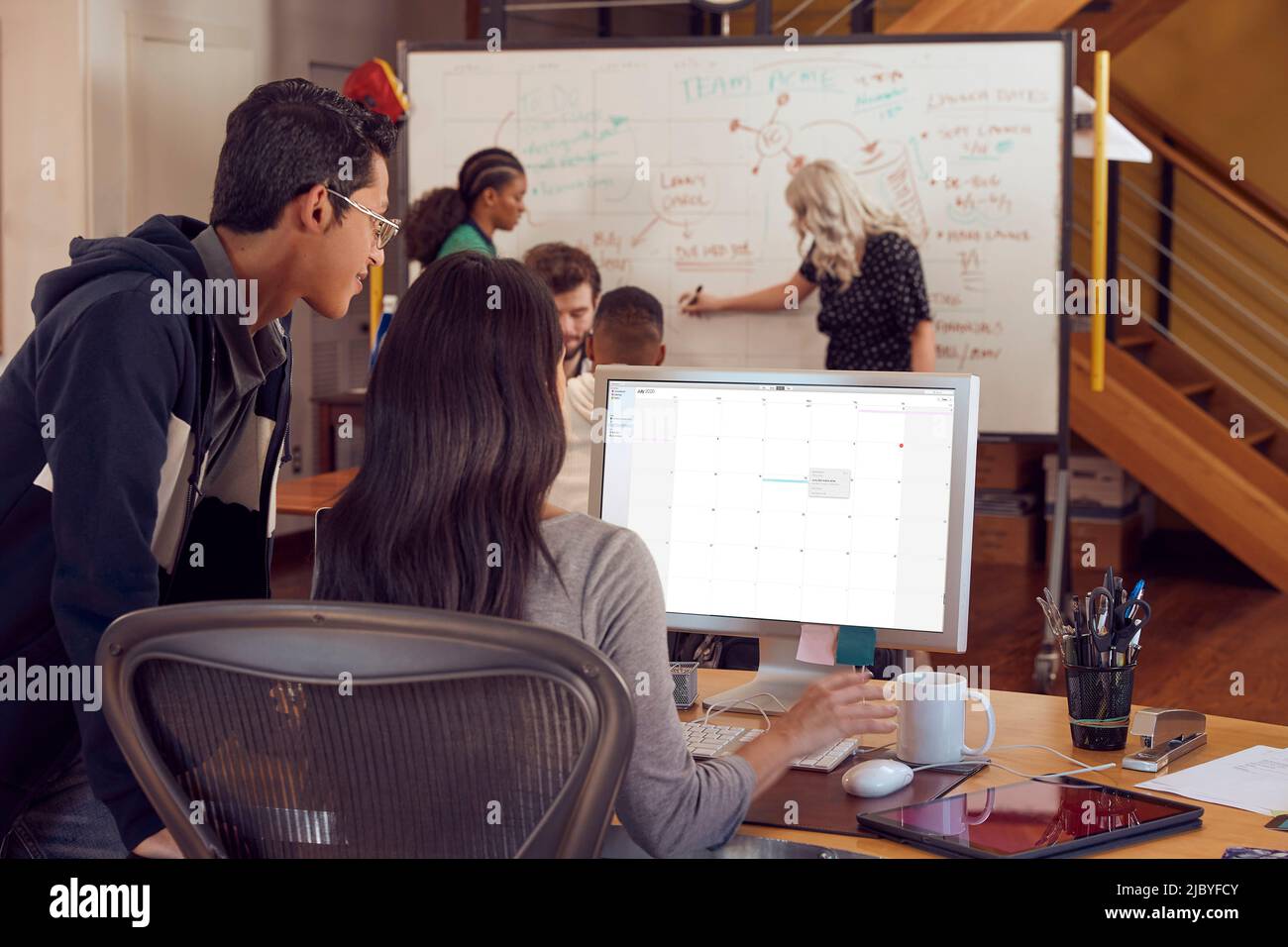 oung coworkers discussing brand strategy, in conference room with