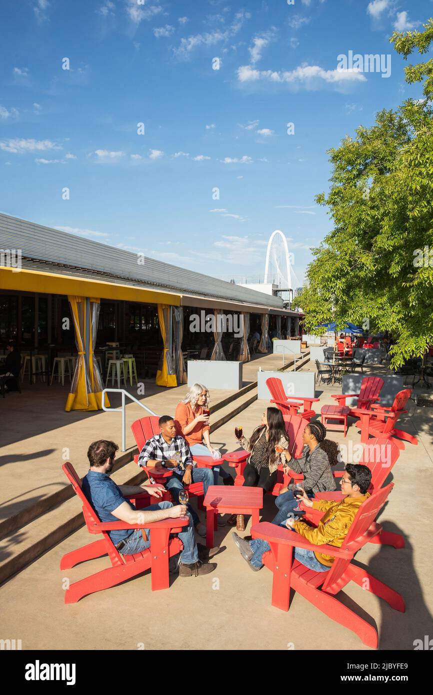 Group of young coworkers hanging out on outdoor patio having drinks