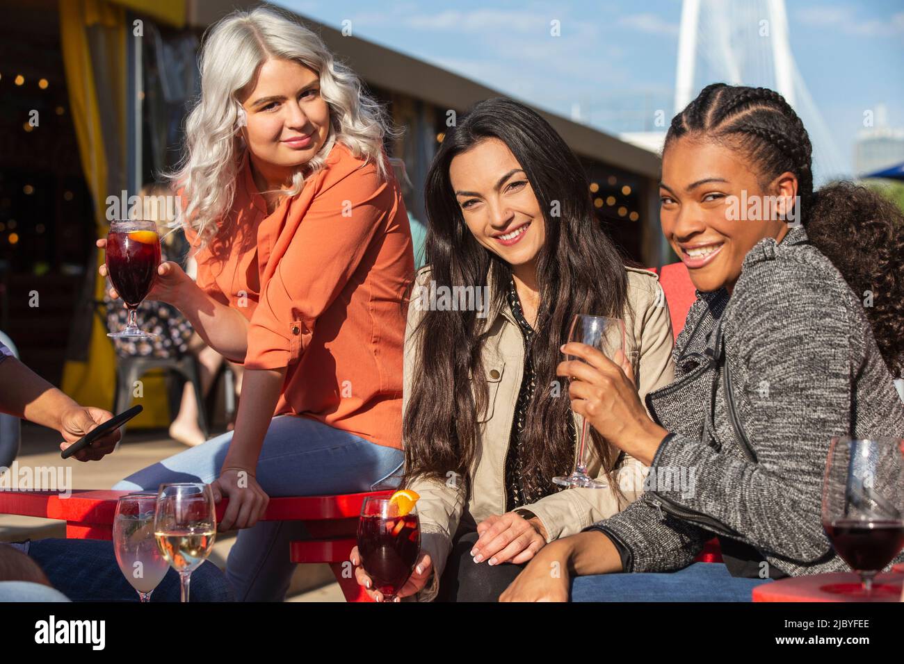 Group of young coworkers hanging out on outdoor patio having drinks
