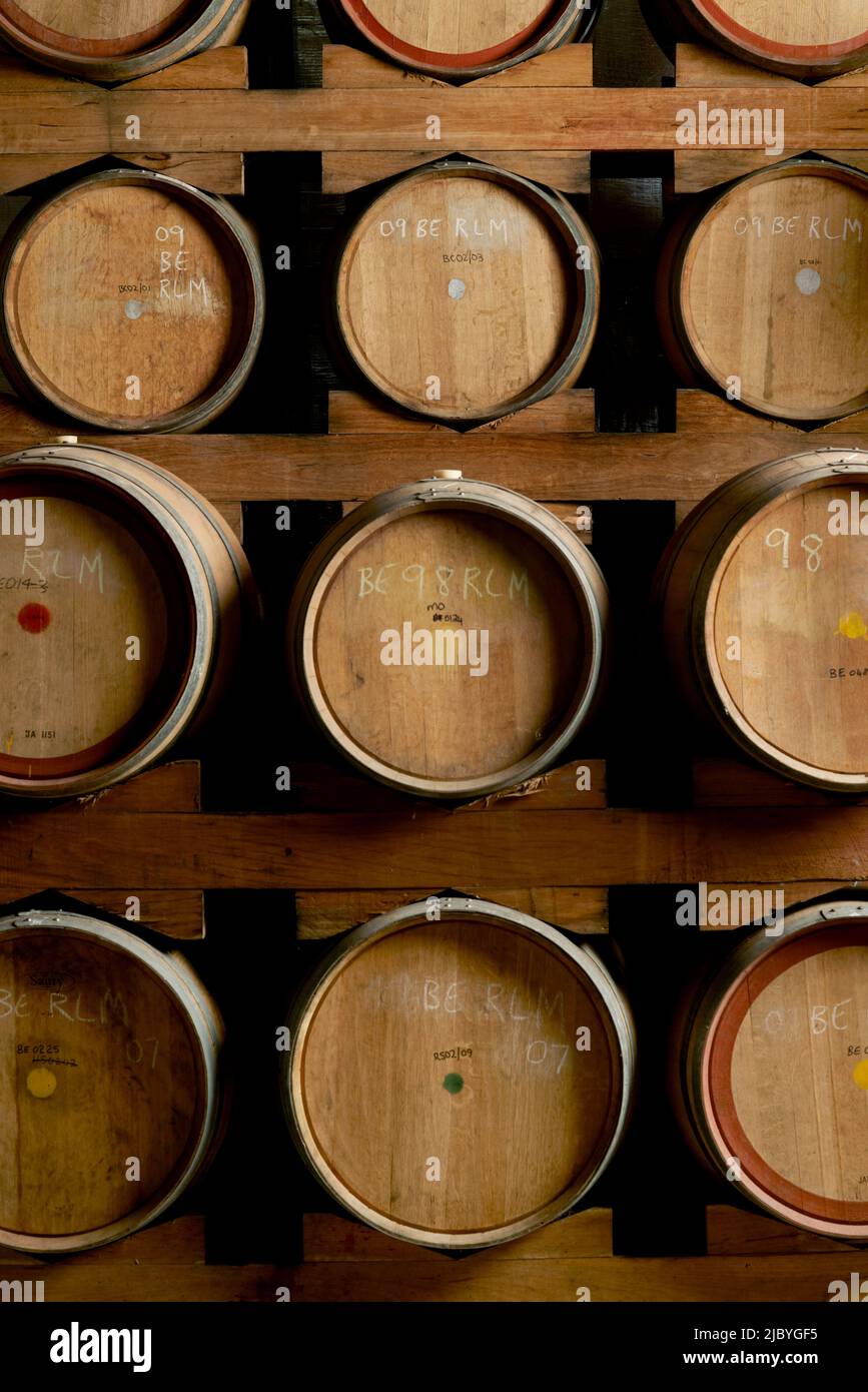 Rows of wine barrels on storage racks in cellar for aging wine Stock Photo