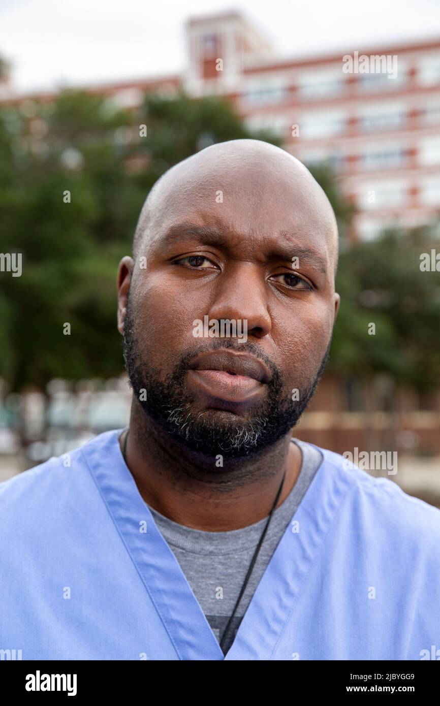 Portrait of middle aged man with beard and a bald head wearing scrubs