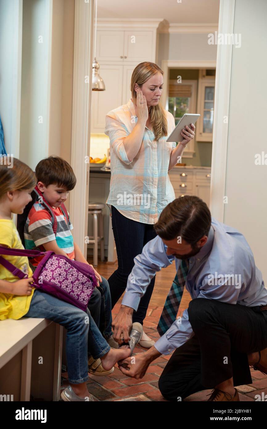 ly in the morning getting, dad getting kids shoes on in mudroom before ...
