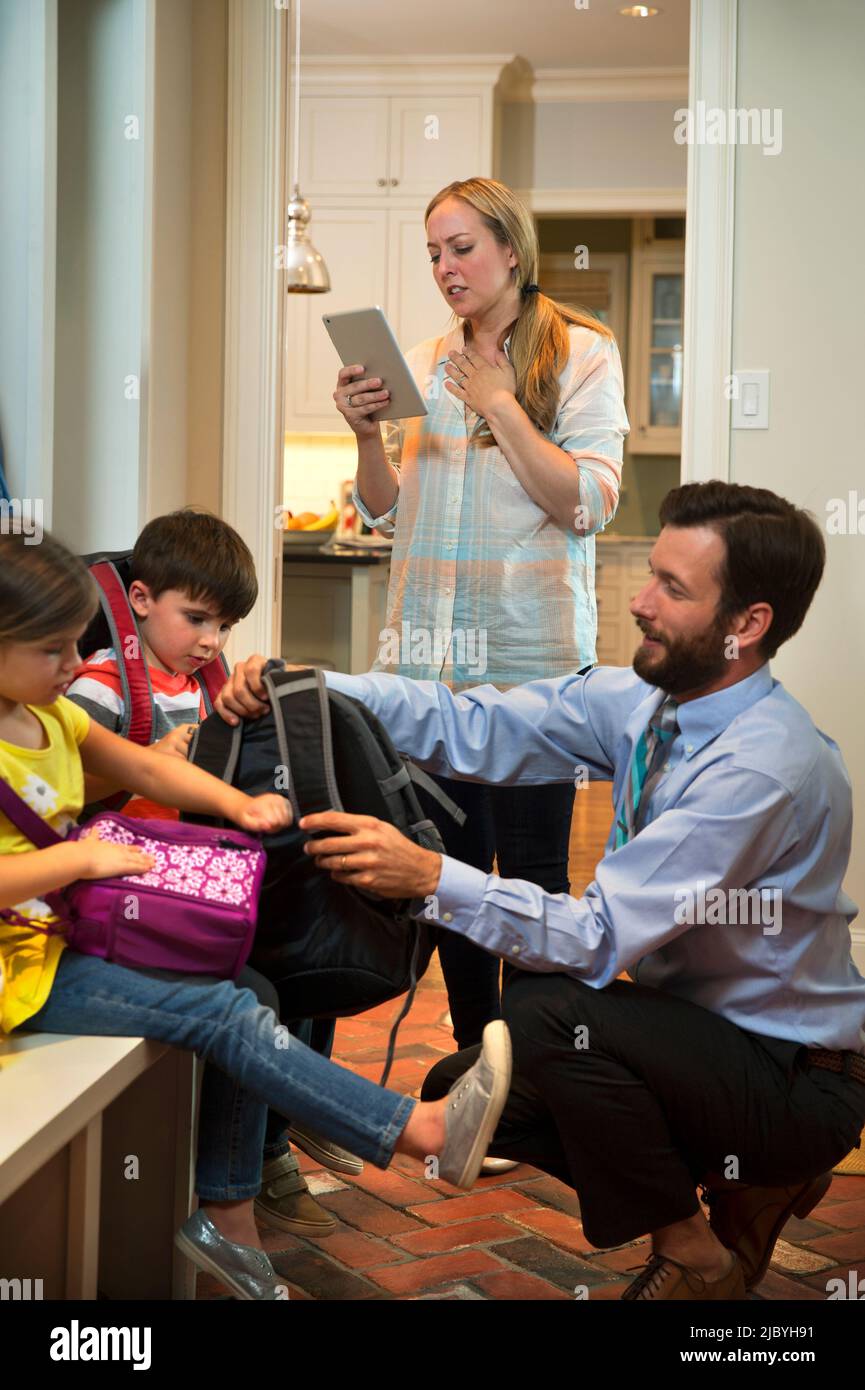 ly in the morning getting, dad getting kids shoes on in mudroom before ...