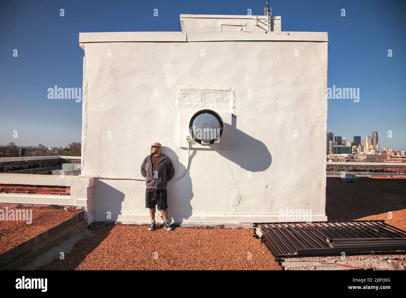 Man leaning on rooftop wall Stock Photo