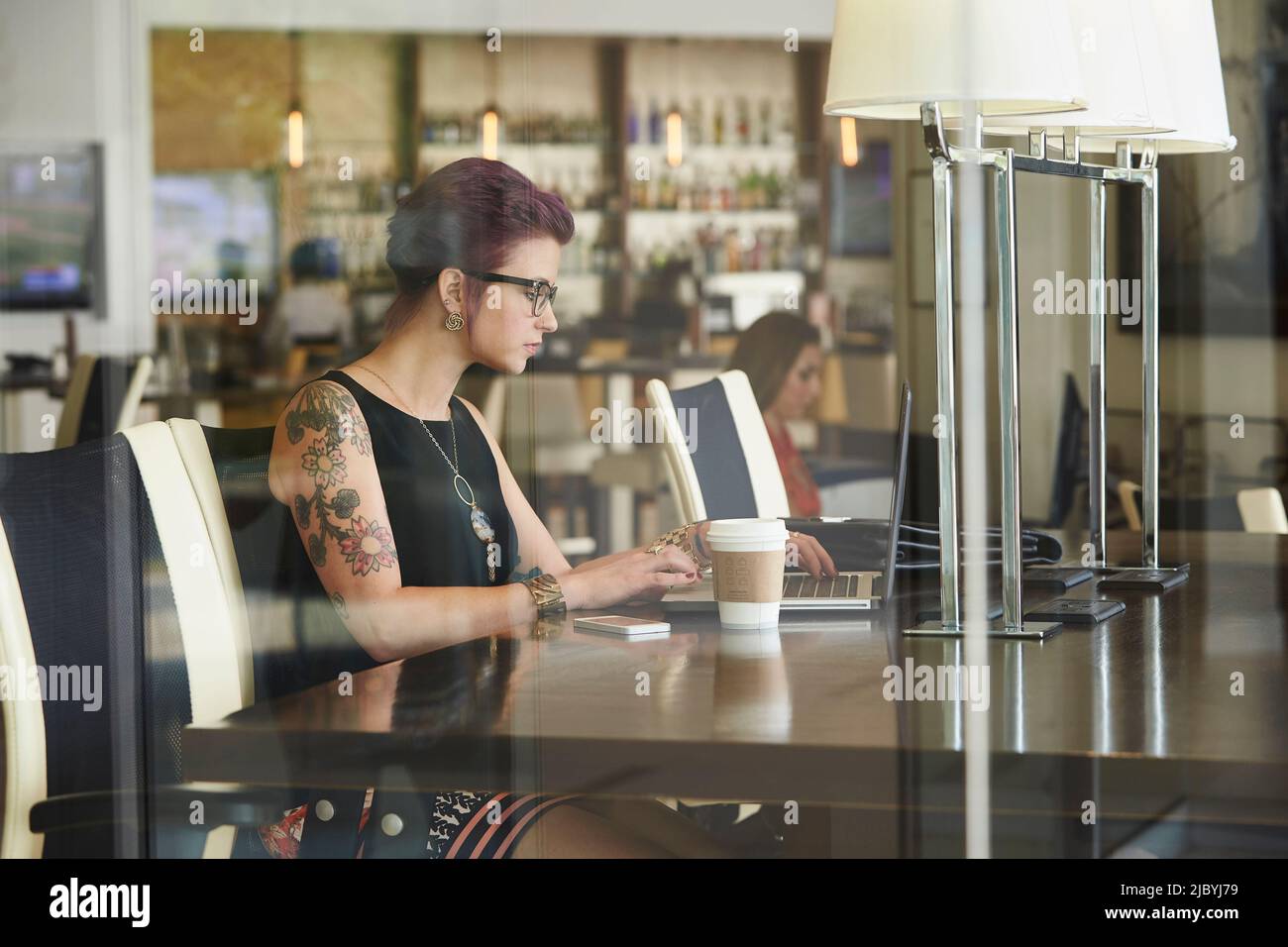 Caucasian woman using laptop in coffee shop Stock Photo