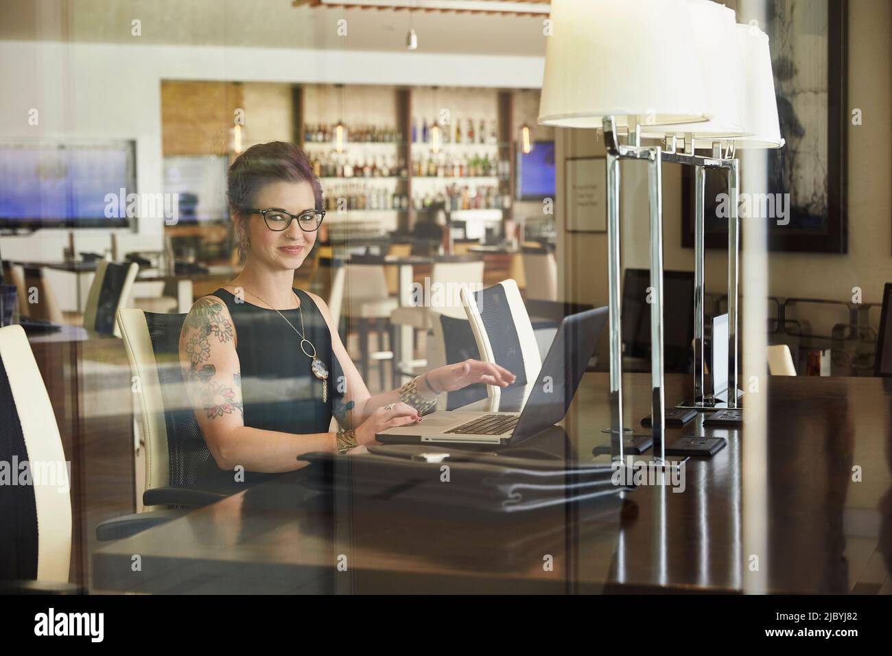 Caucasian woman using laptop at restaurant table Stock Photo