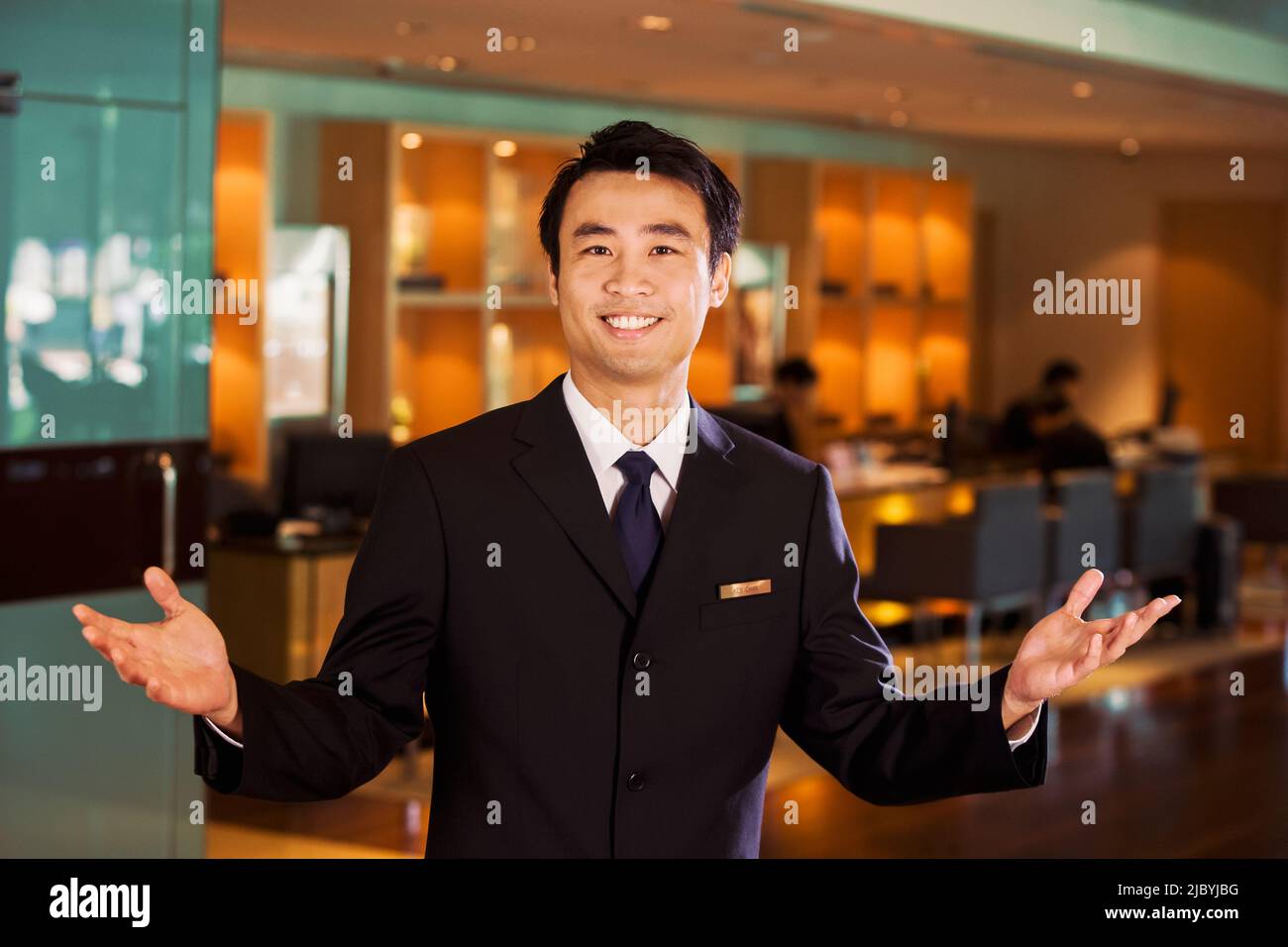 Chinese businessman in bar welcoming guests Stock Photo