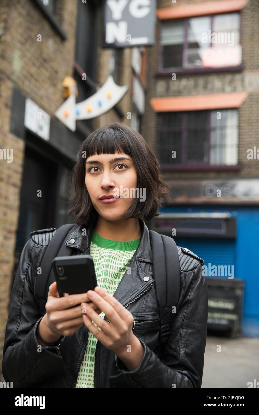 Woman walking the streets of London using mobile phone Stock Photo