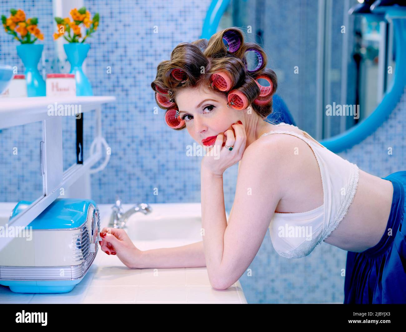 Vintage woman changing the radio station in bathroom in a mid century