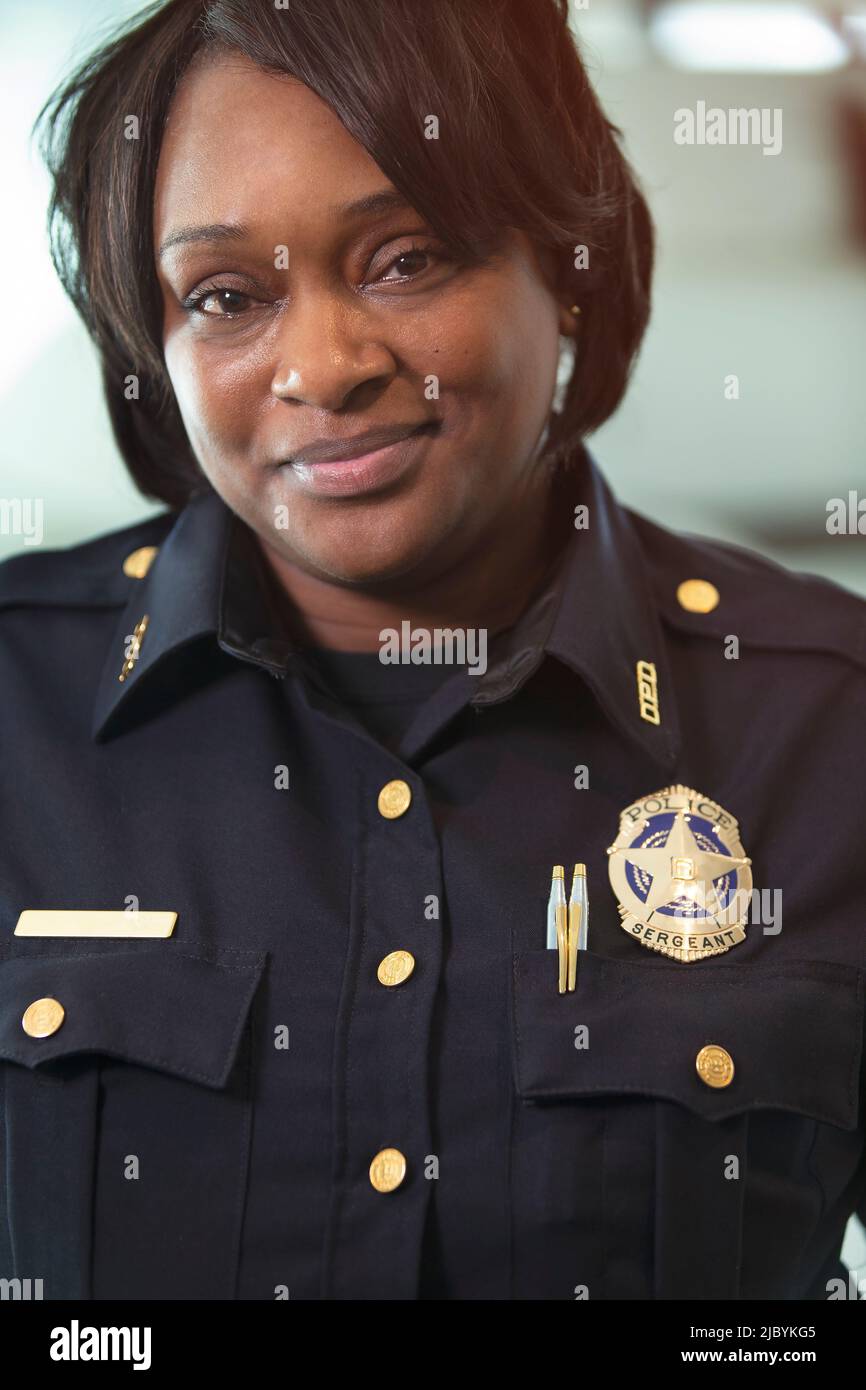 Portrait of Police woman Sergeant standing looking towards camera smiling Stock Photo