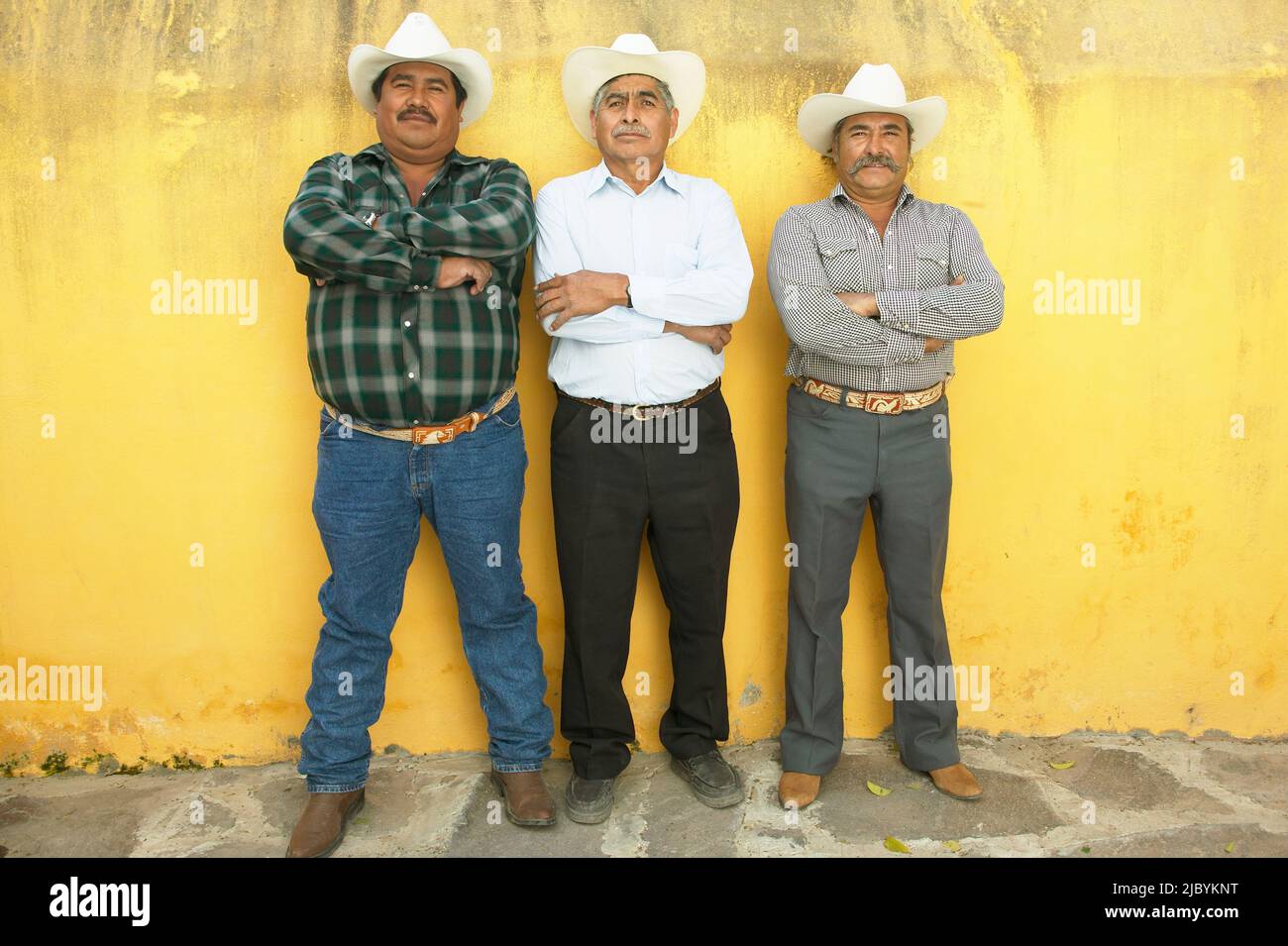 Three men standing with arms crossed Stock Photo