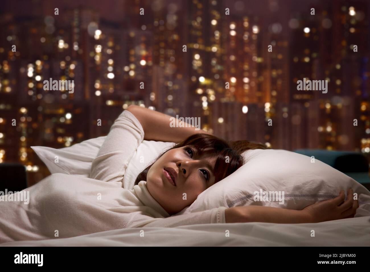 Woman laying on bed Stock Photo