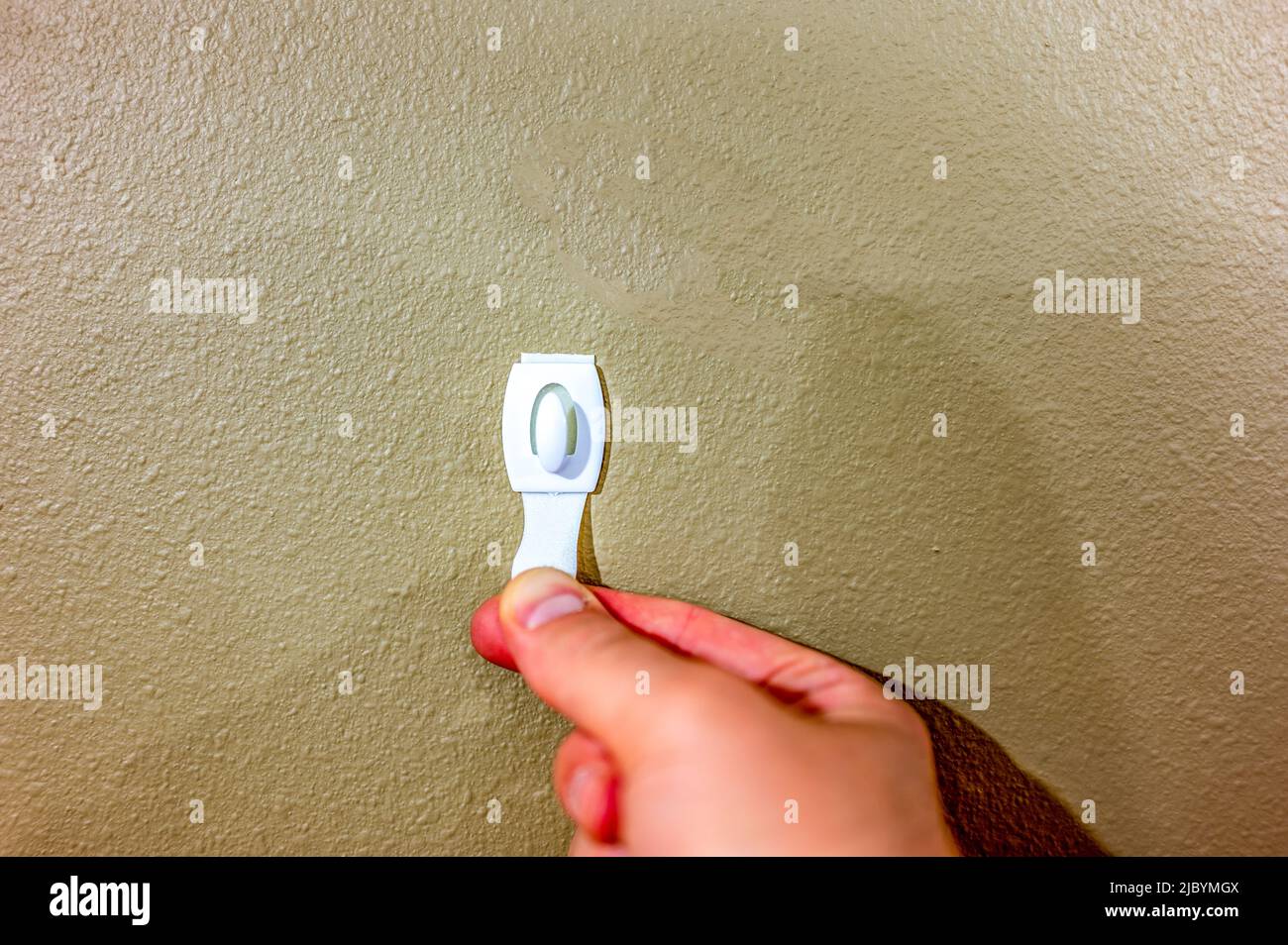 Selective focus on adhesive strip wall hanger that can be removed by