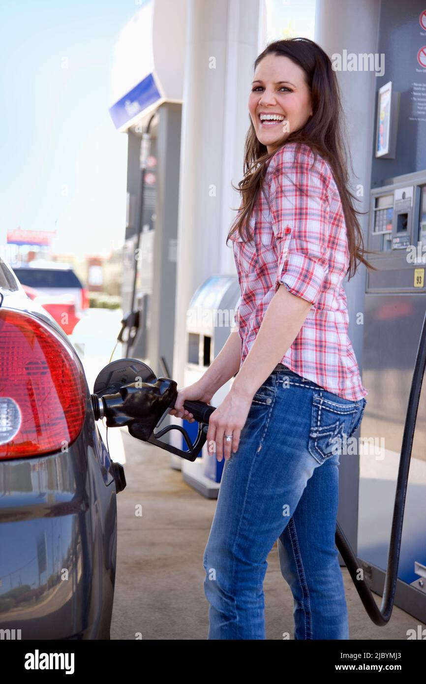 Woman pumping gas at gas station Stock Photo Alamy