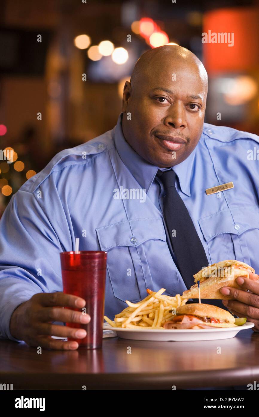 Uniform officer sitting holding smiling food and drink hires stock