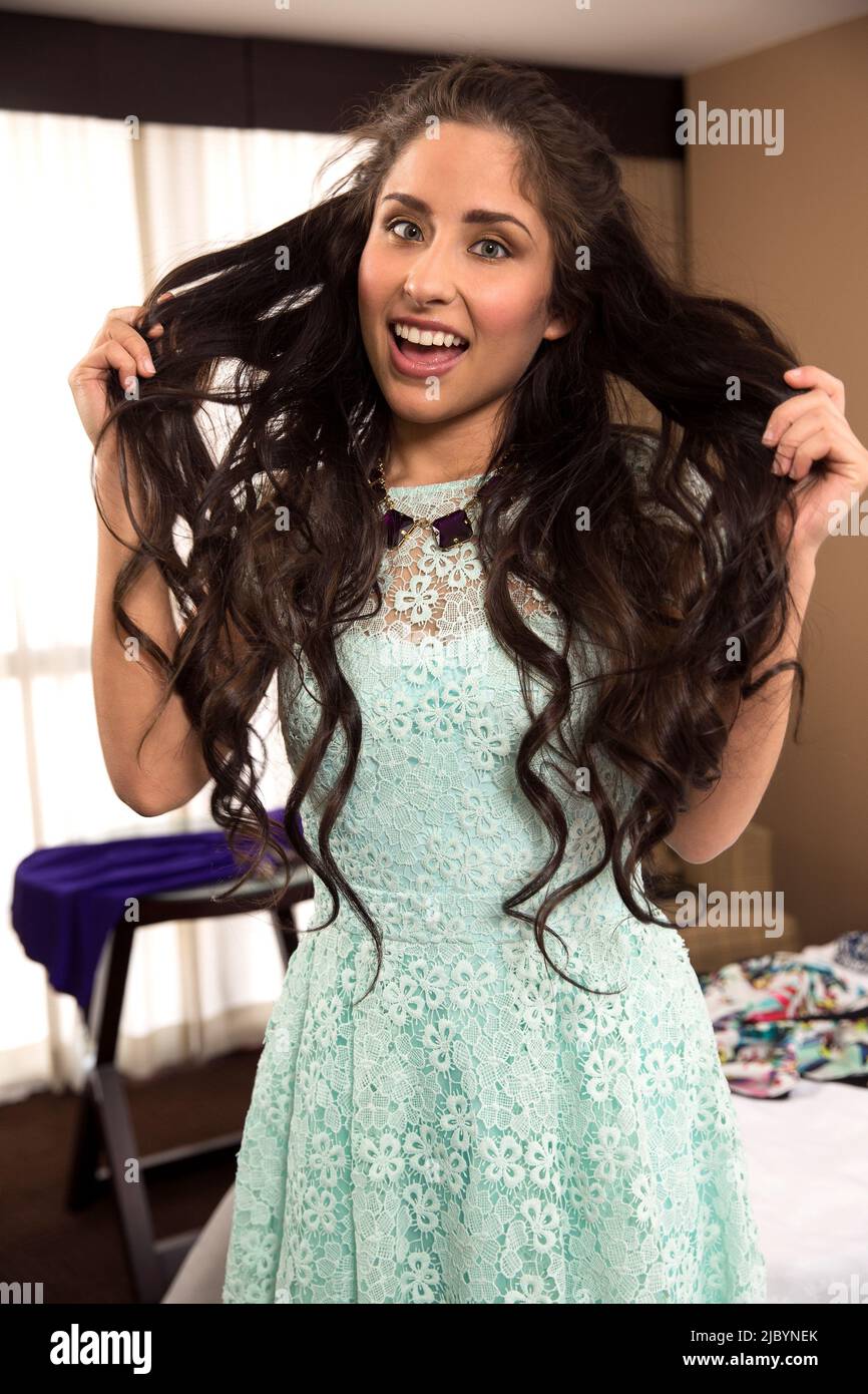 Hispanic woman pulling hair in hotel room Stock Photo