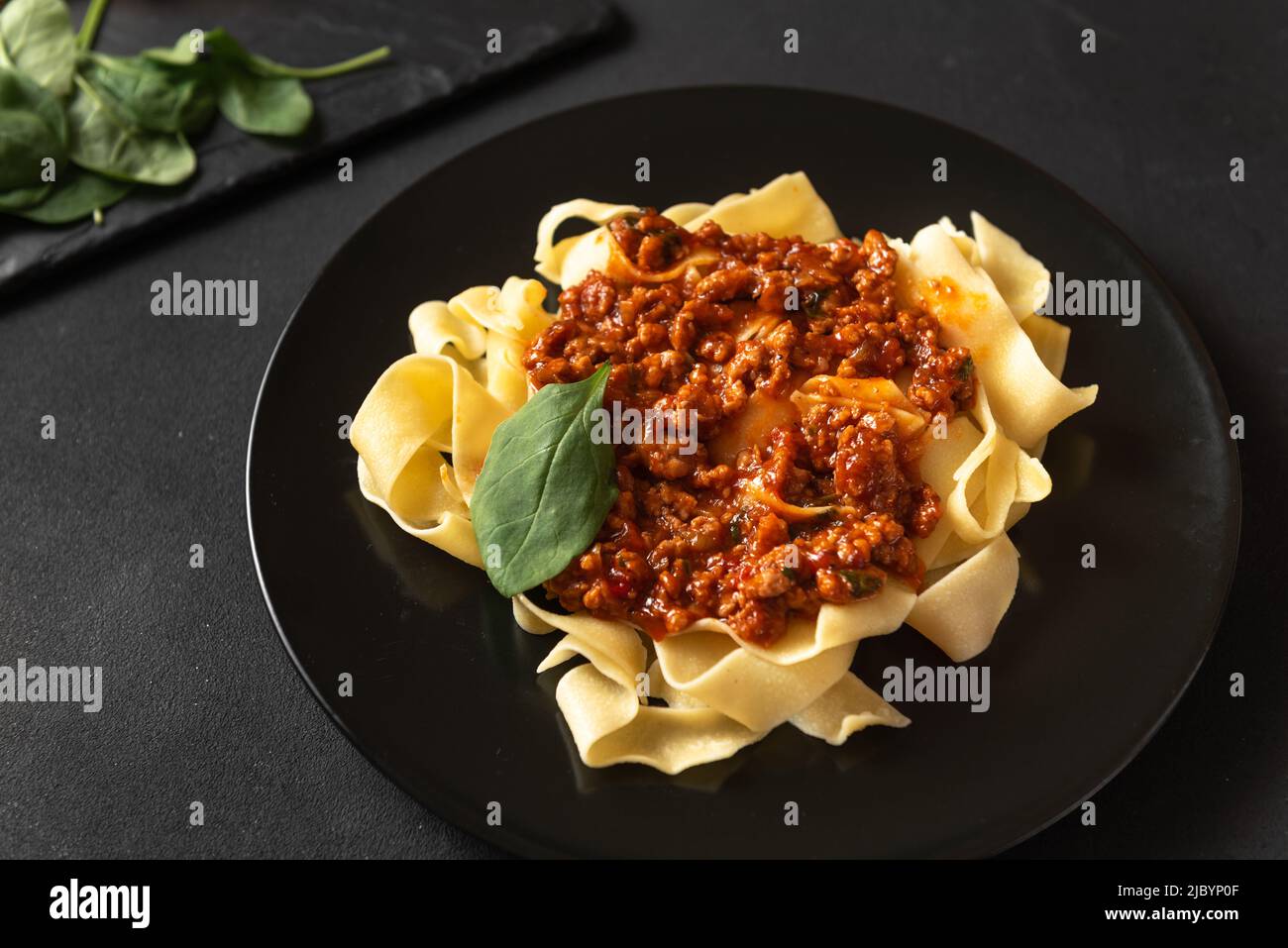 Pappardelle pasta with prosciutto and cheese sauce on a plate. Food and drink Stock Photo