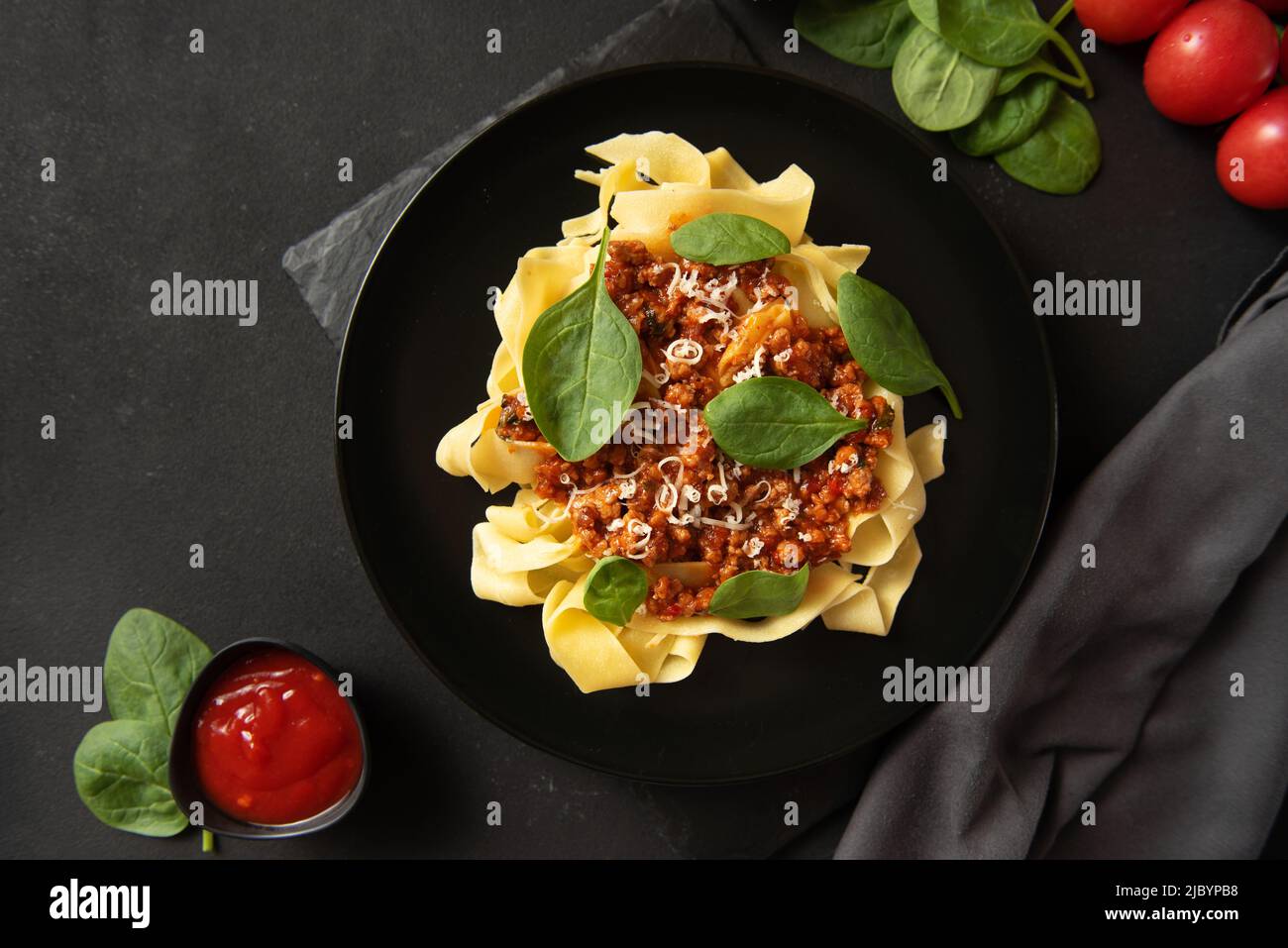 Pasta with sauce and basil on a dark background. Top view. Stock Photo