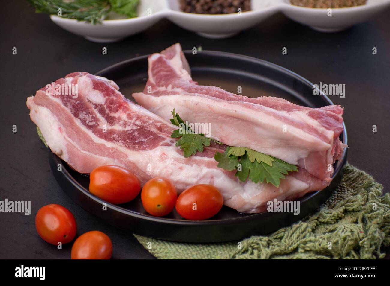 Pieces of raw pancetta pork with cherry tomatoes Stock Photo Alamy
